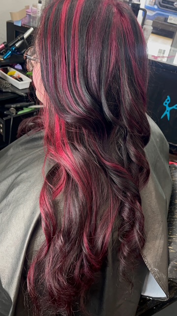 Vibrant red and pink highlights on dark hair, creative color in Spring, TX
